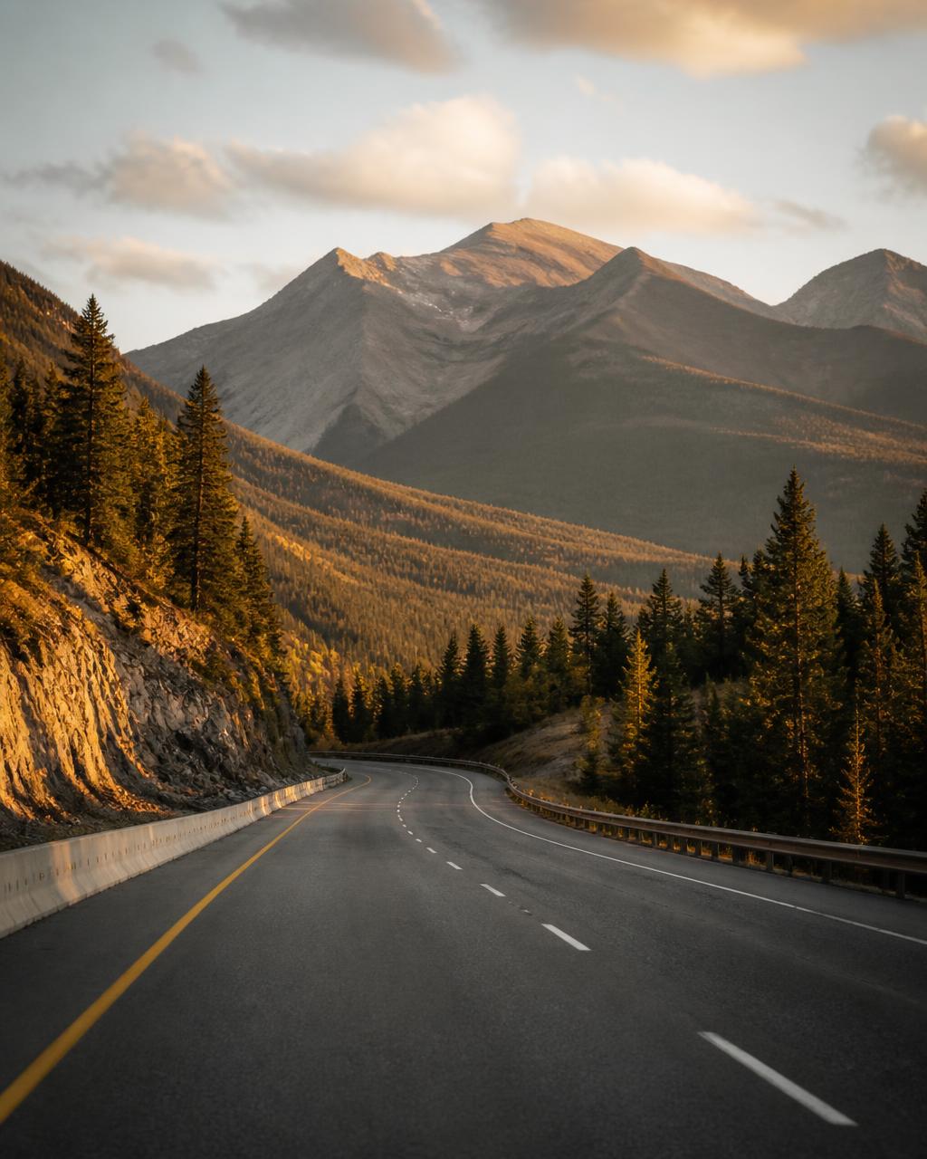 An open American interstate highway curving through mountains at golden hour